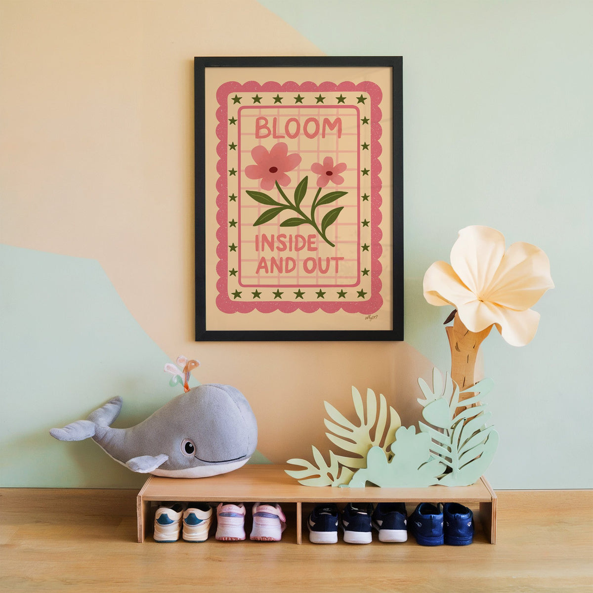 Bloom inside and out pink floral nursery print in a black frame on a mint and peach wall above a whale plush