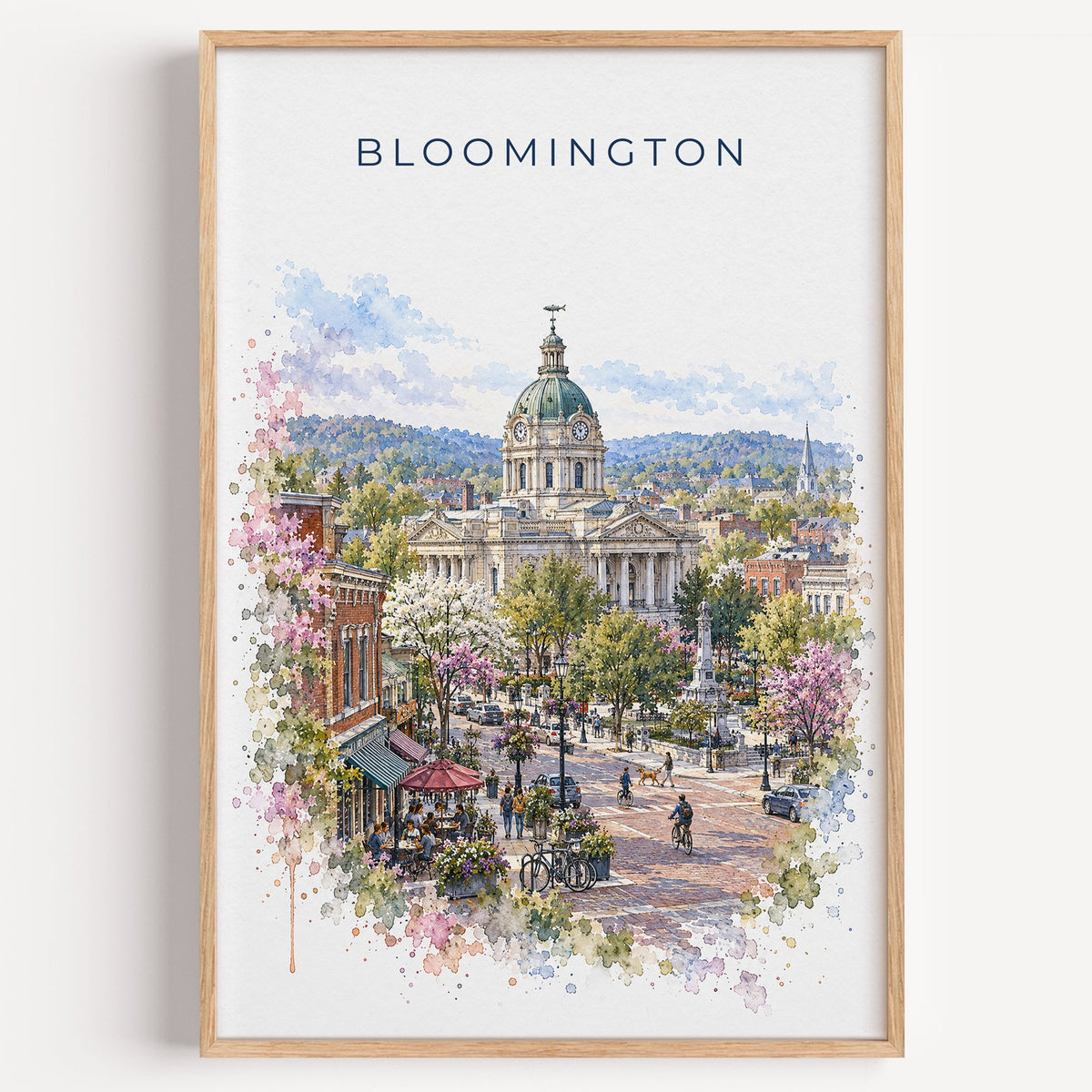 Bloomington, Indiana watercolor print in a light oak frame on a plain white wall