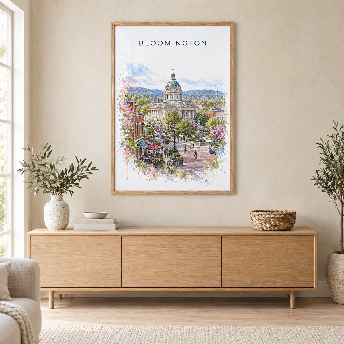 Bloomington, Indiana watercolor print in an oak frame above a light wood sideboard in a Scandinavian living room