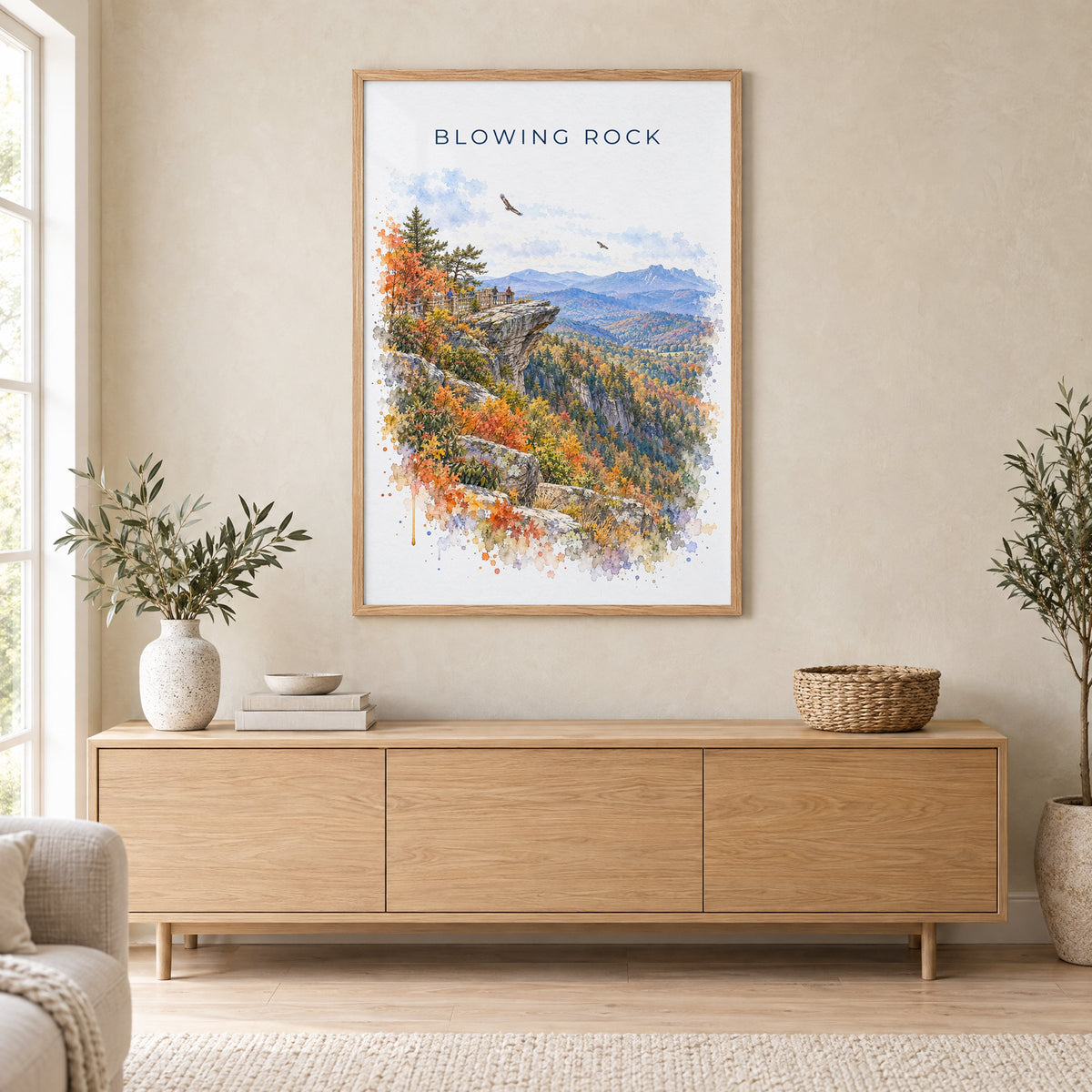Blowing Rock watercolor print in an oak frame above a light wood sideboard in a Scandinavian living room