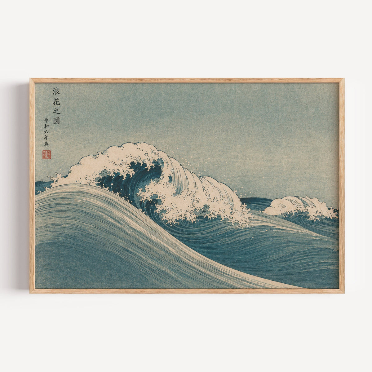 Blue crashing wave woodblock print in a light oak frame on a plain white wall