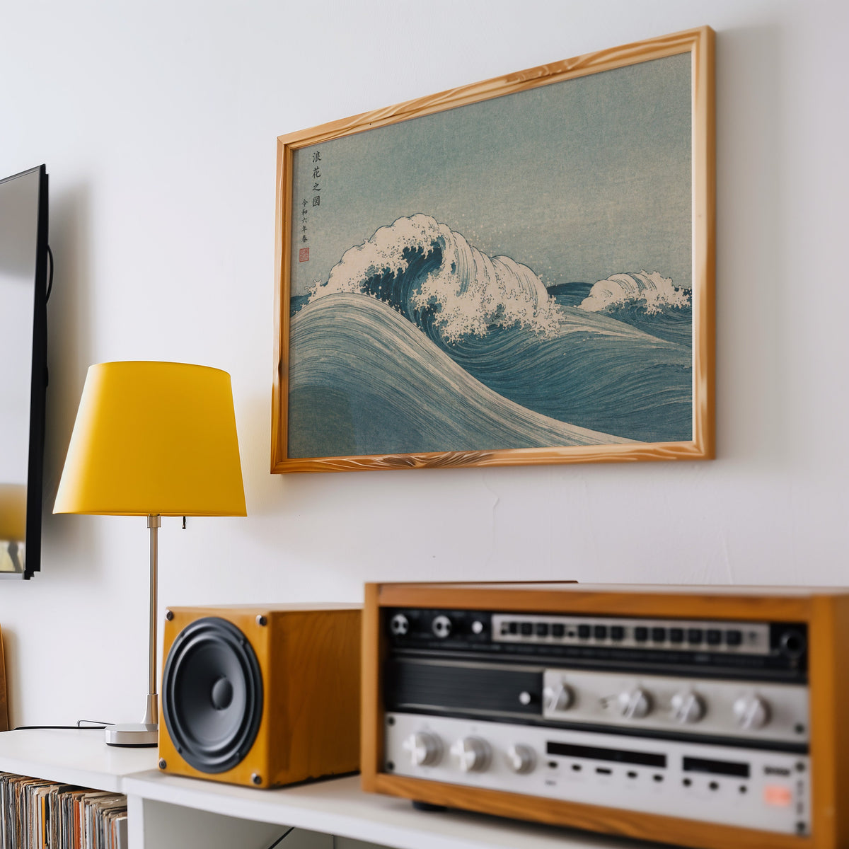 Blue crashing wave woodblock print in a pine frame above a vintage stereo and a yellow table lamp