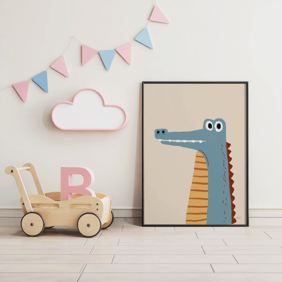 Upright blue crocodile on cream nursery print in a black frame under pastel bunting by a wooden baby walker