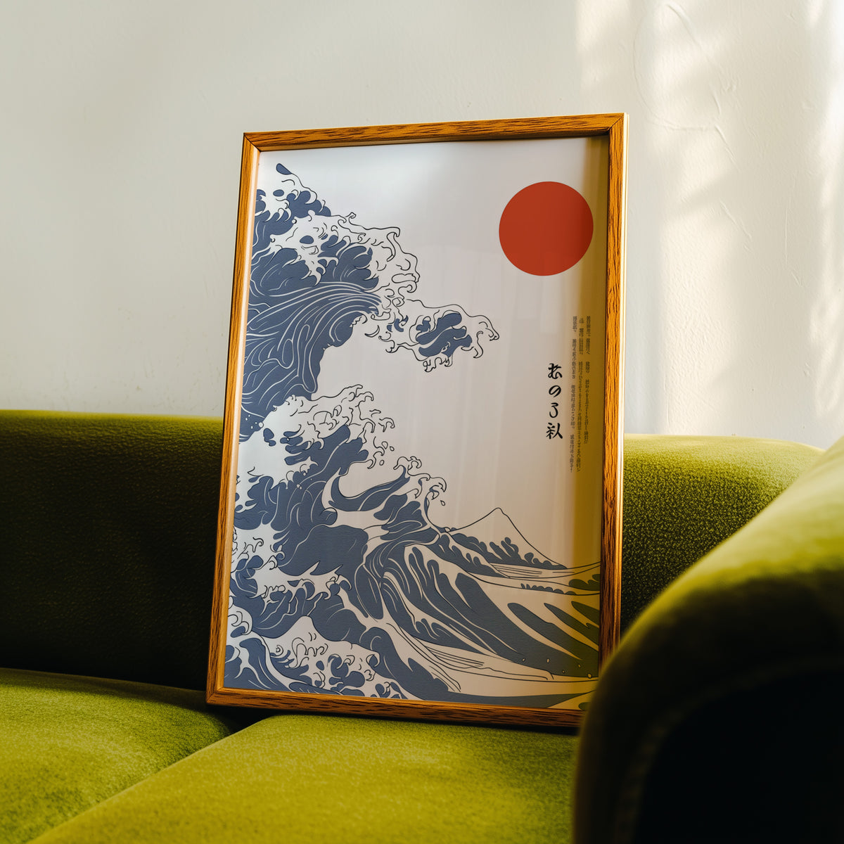 Blue Great Wave with red sun print in an oak frame propped on a green velvet sofa