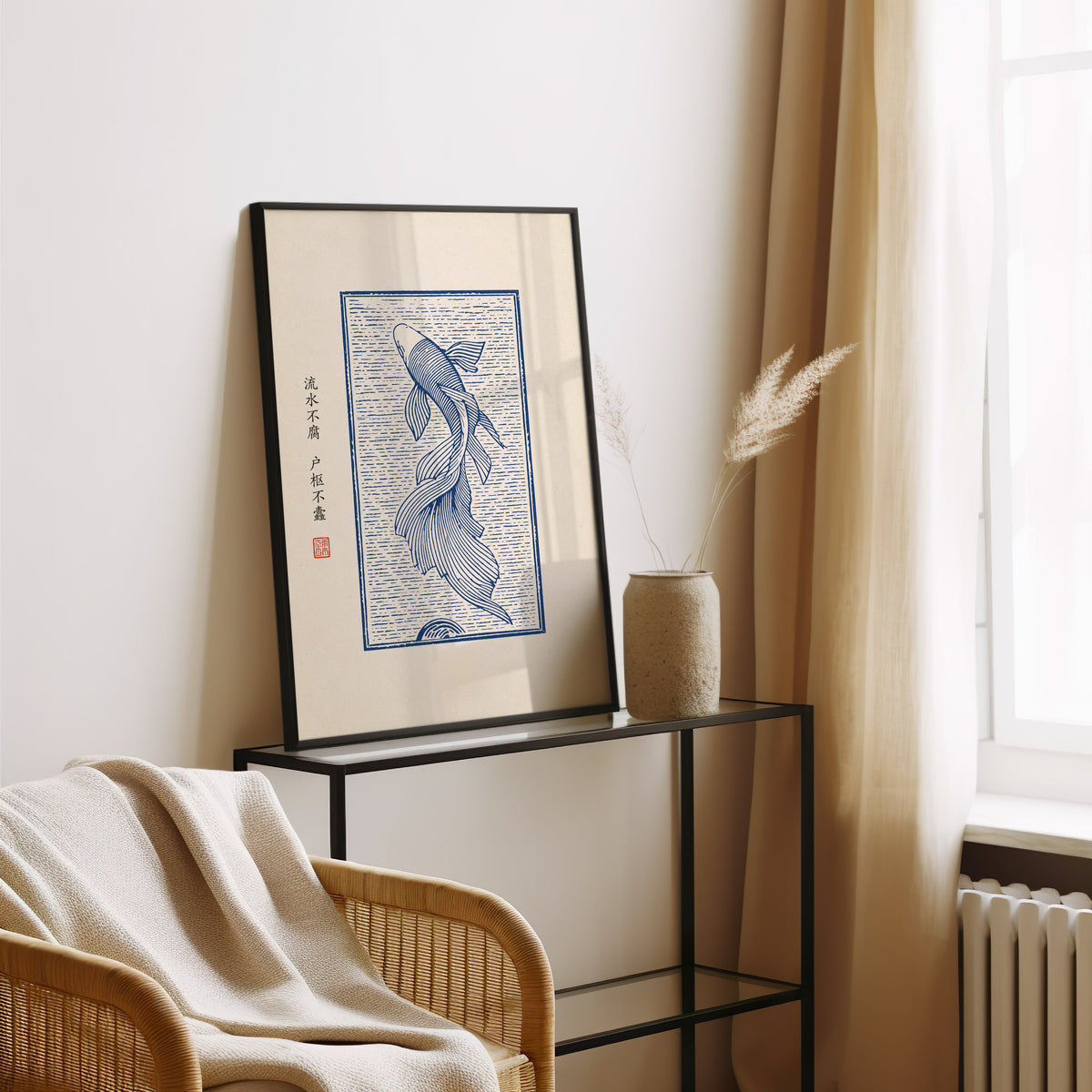Blue line koi flowing water poster in a black frame leaning on a glass console beside pampas grass