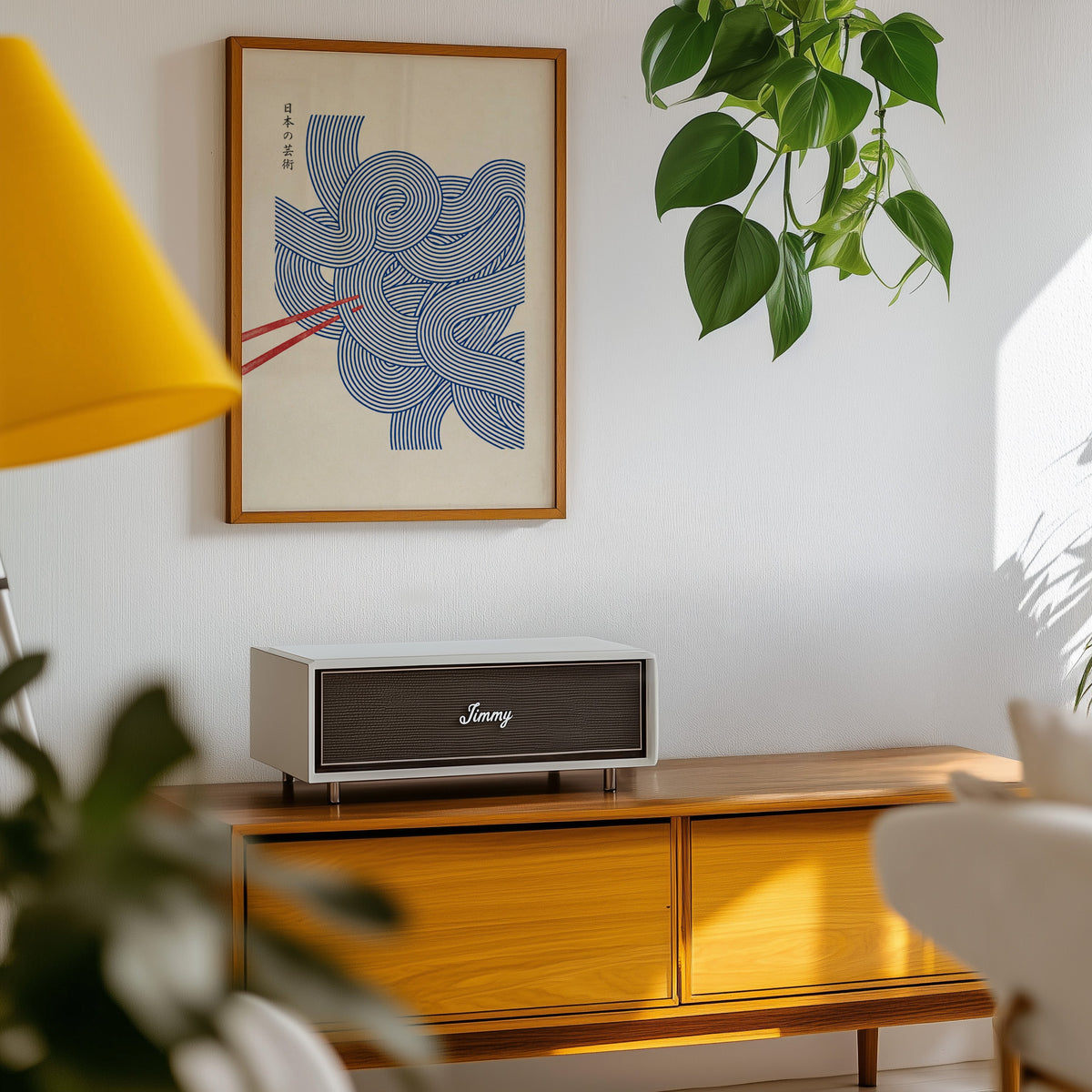 Blue line noodles poster in an oak frame above a teak mid-century sideboard with trailing pothos