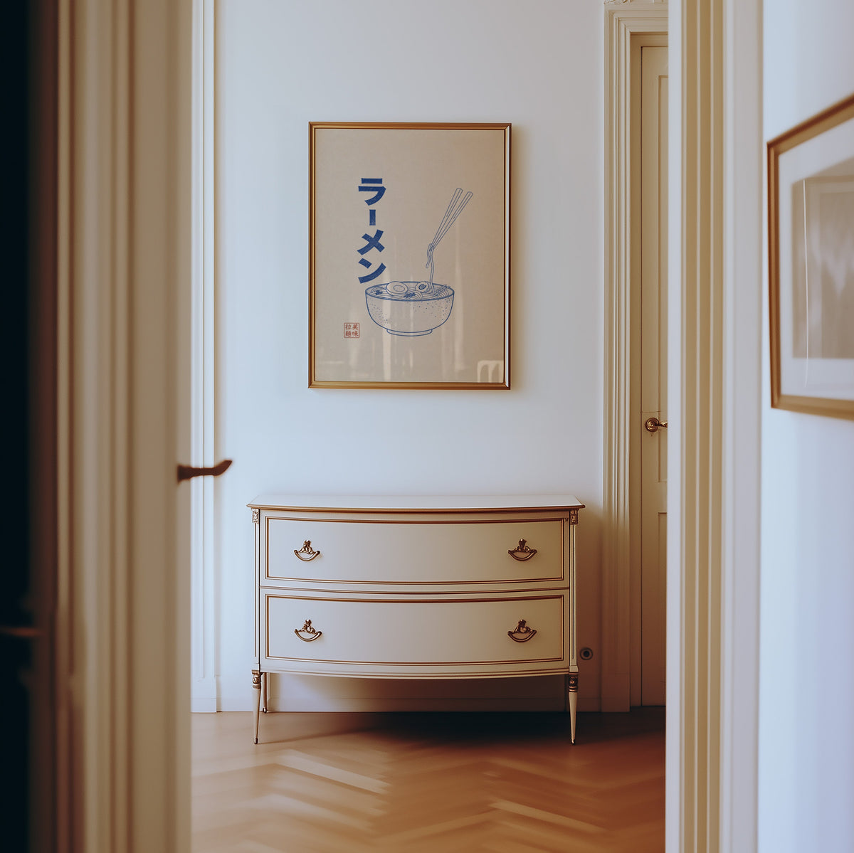 Blue line ramen bowl poster shown in a gold frame in a hallway above a cream dresser