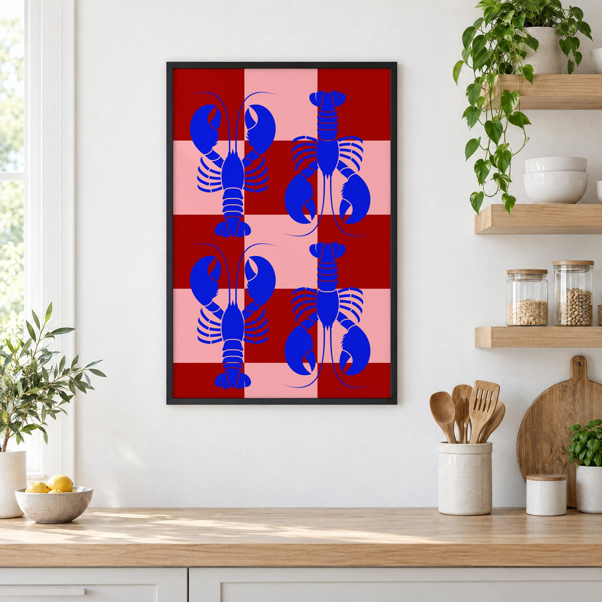 Blue lobster red pink checker print in a black frame in a white kitchen beside open wood shelves and glass jars
