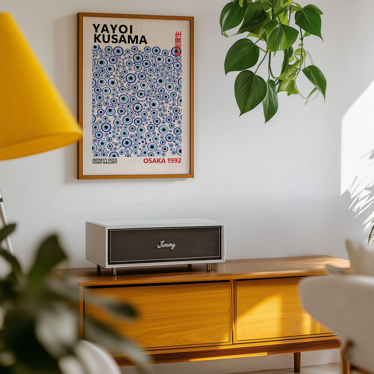 Yayoi Kusama inspired turquoise evil eye print above a sideboard with a plant