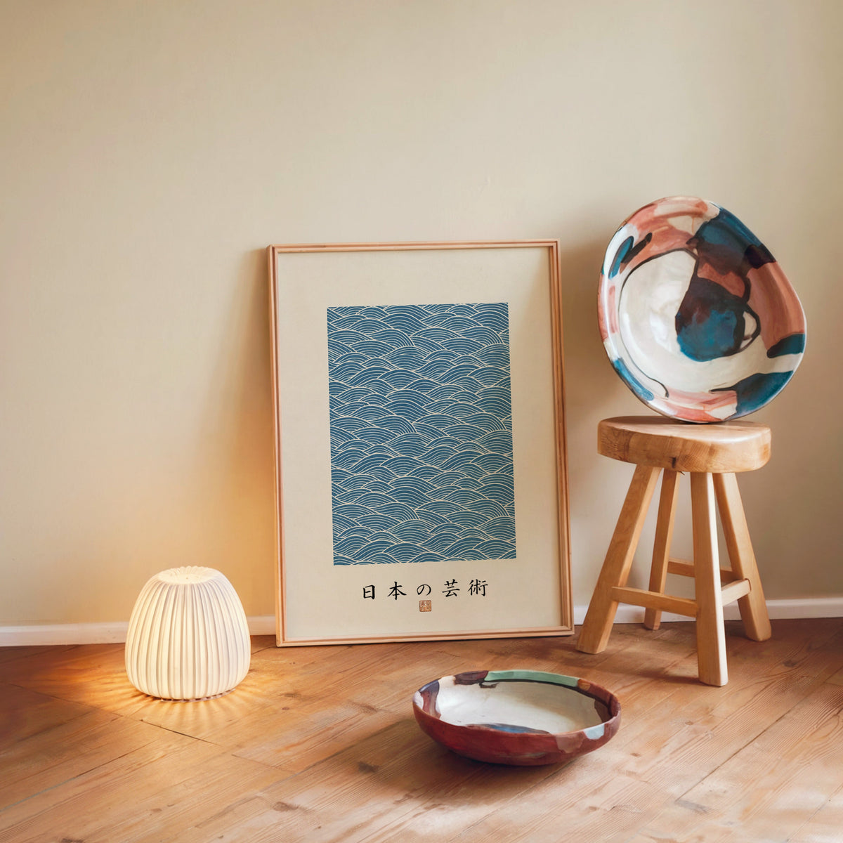 Blue wave line pattern poster in a light wood frame leaning on a wooden floor by a glowing lamp and stool