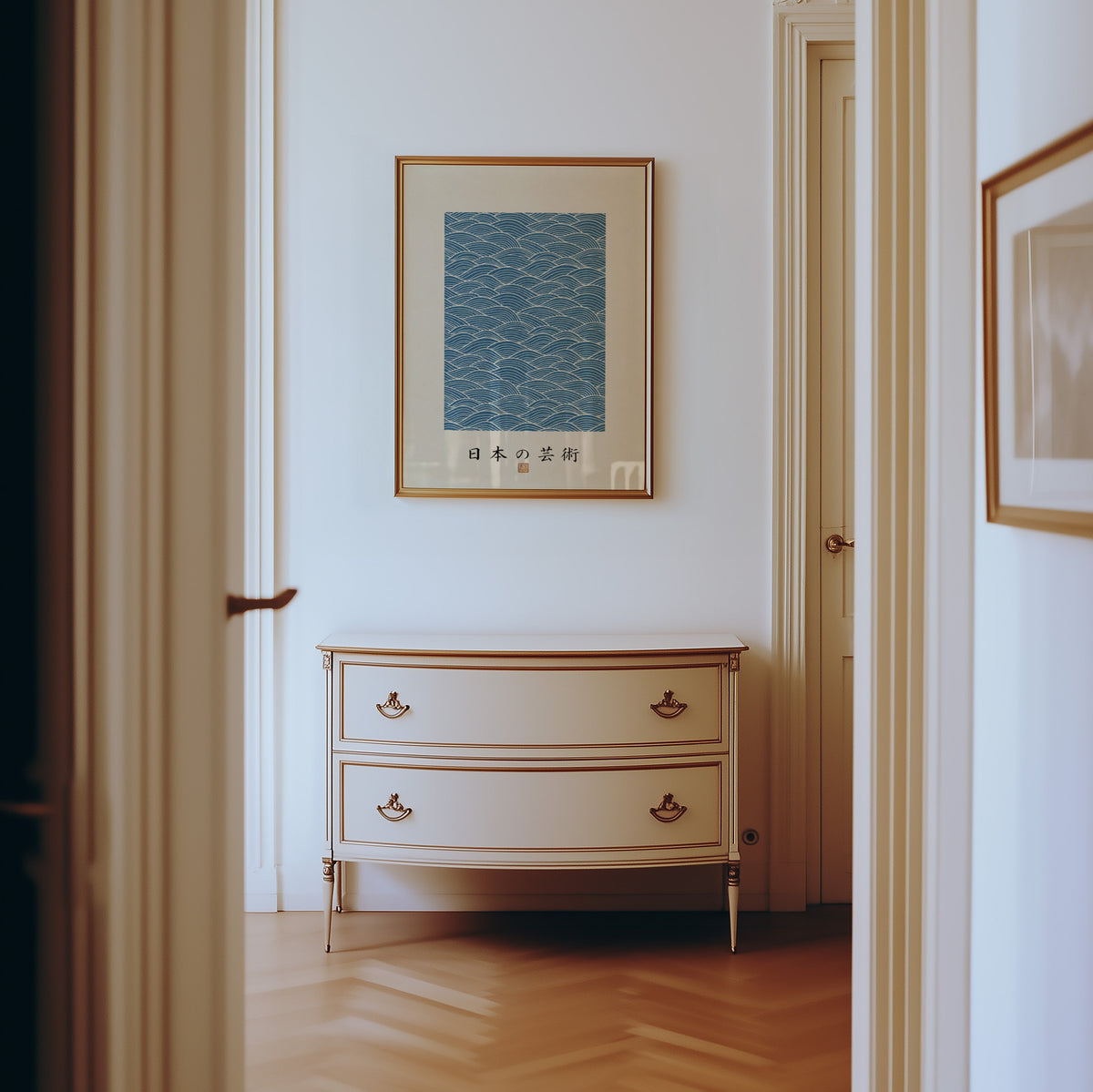 Blue wave line pattern poster shown in a gold frame in a hallway above a cream dresser