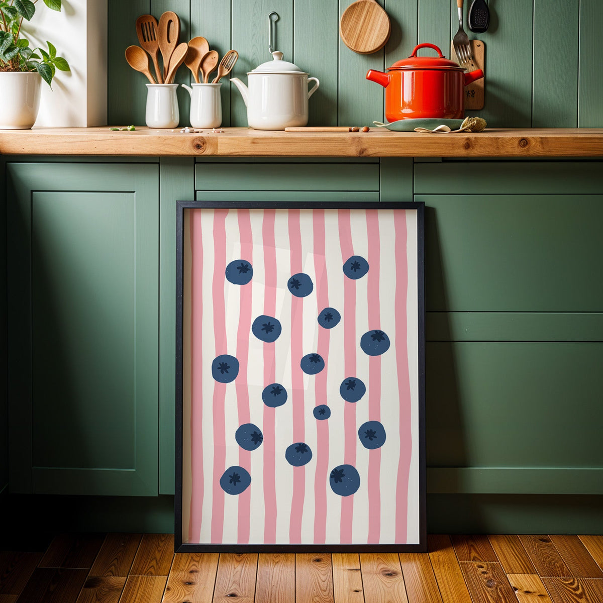 Blueberry stripe print in a black frame against sage green kitchen cabinets