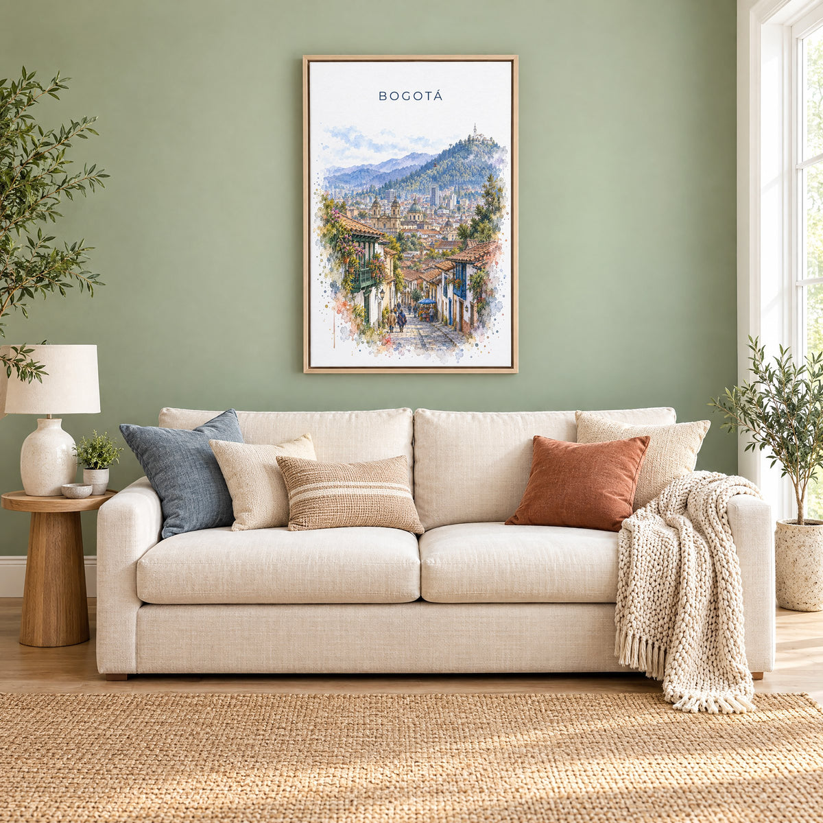 Bogotá watercolor print as a natural floater canvas above a cream linen sofa on a sage green wall