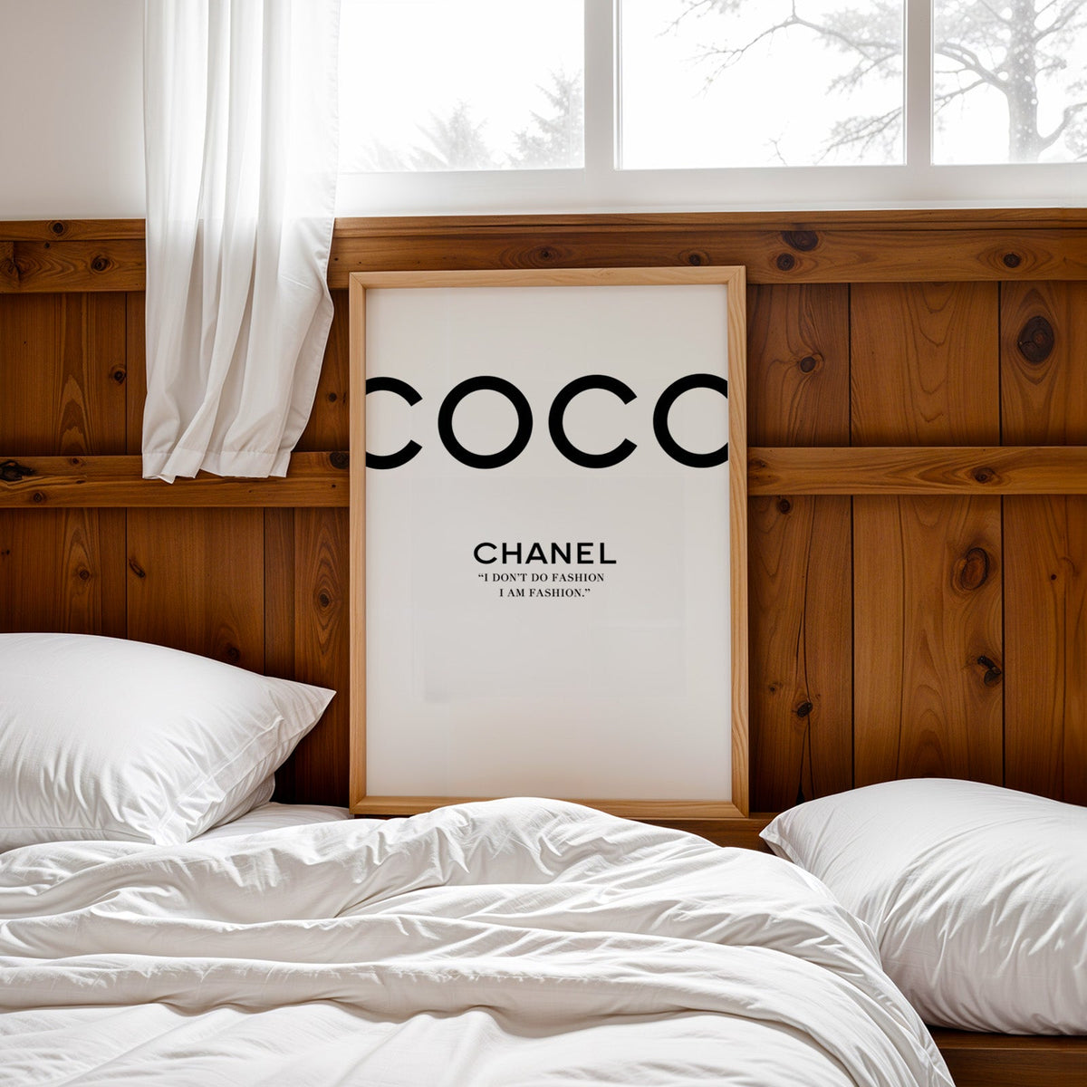 Giant cropped black letters with fashion quote print in a pine frame leaning on a wood headboard over white bedding