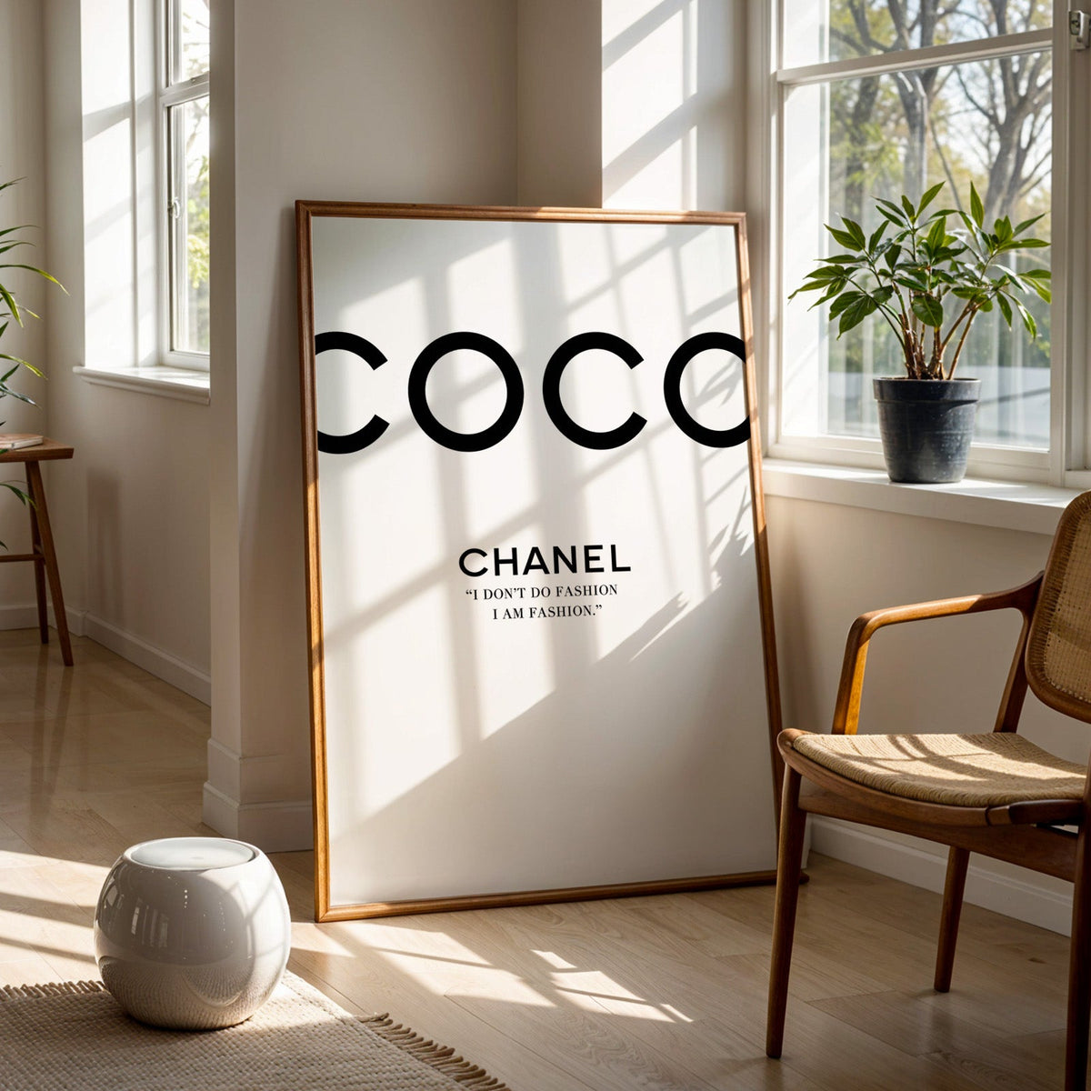 Giant cropped black letters with fashion quote print in a walnut frame on a wood floor beside a cane chair and sunny window