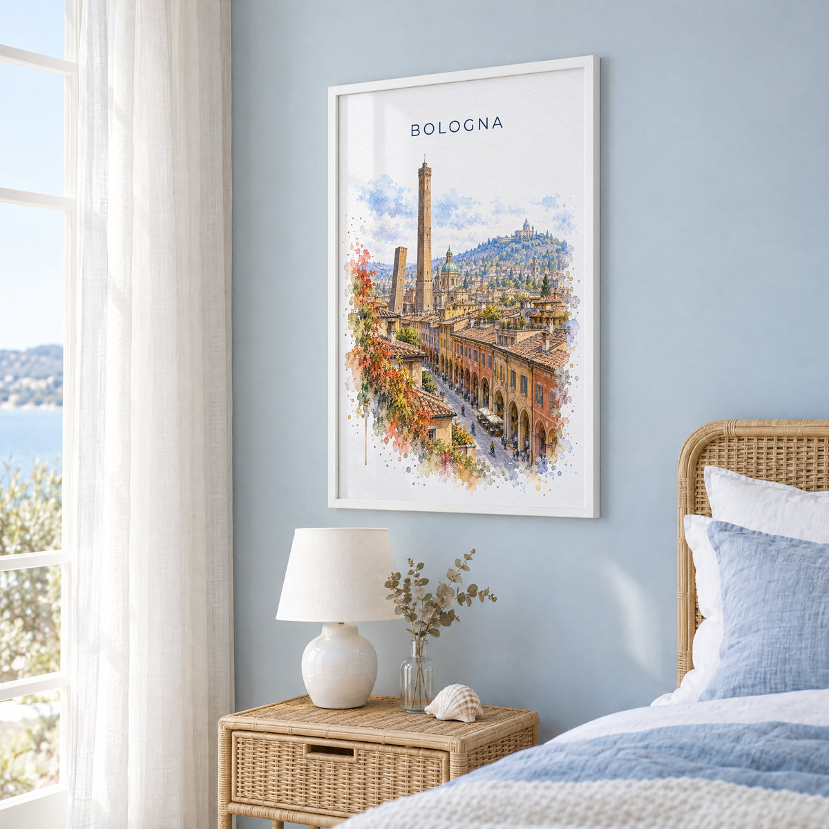 Bologna watercolor print in a white frame on a pale blue wall beside a rattan bed in a coastal bedroom