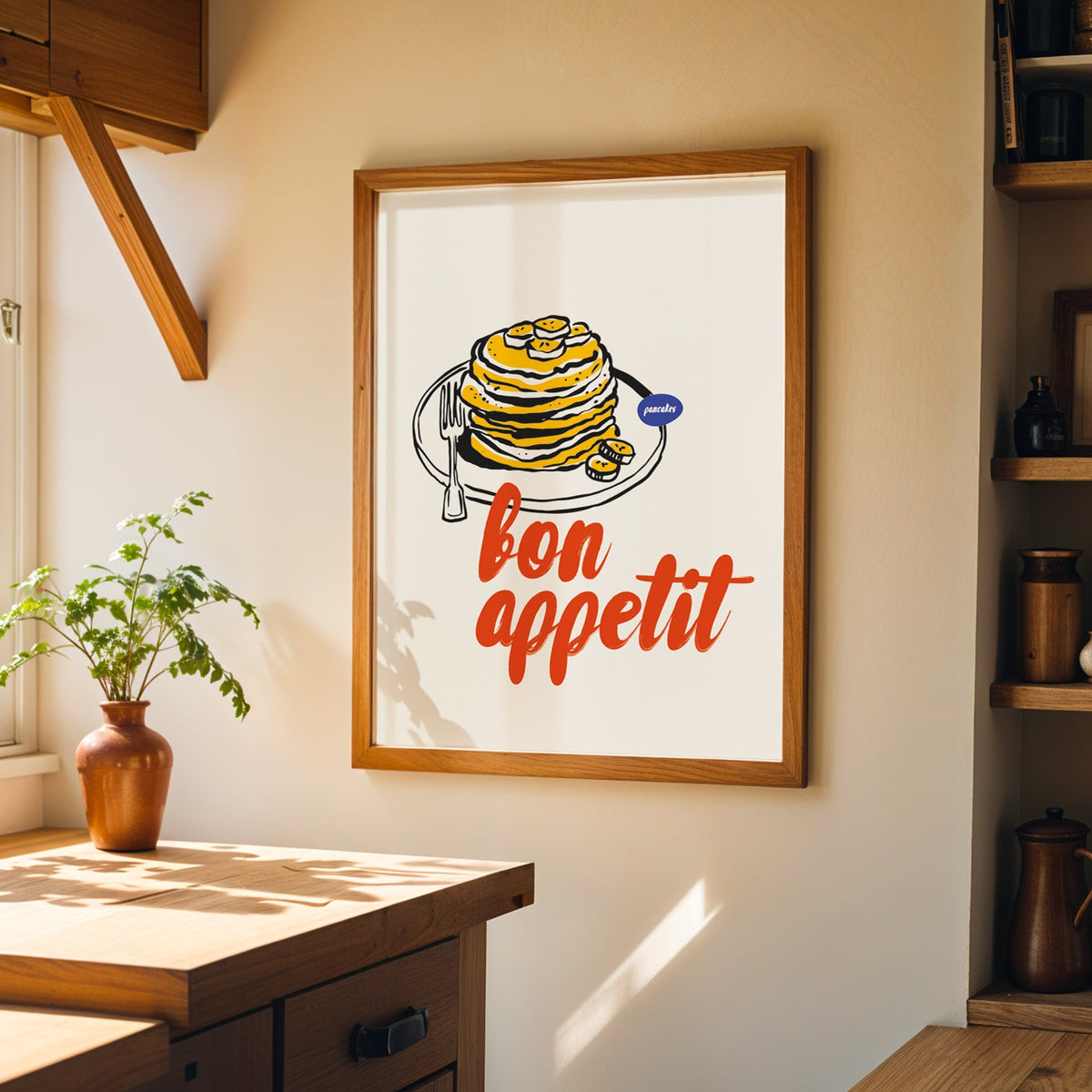 Bon Appetit pancakes print in a walnut frame on a cream kitchen wall above the island