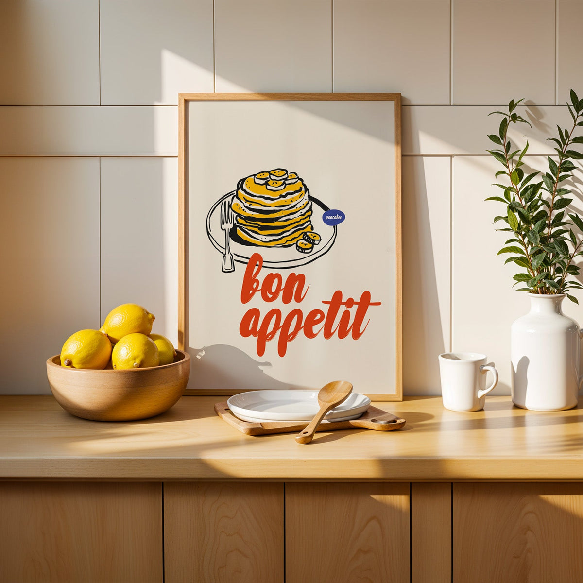 Bon Appetit pancakes print in a slim oak frame beside a wooden bowl of lemons