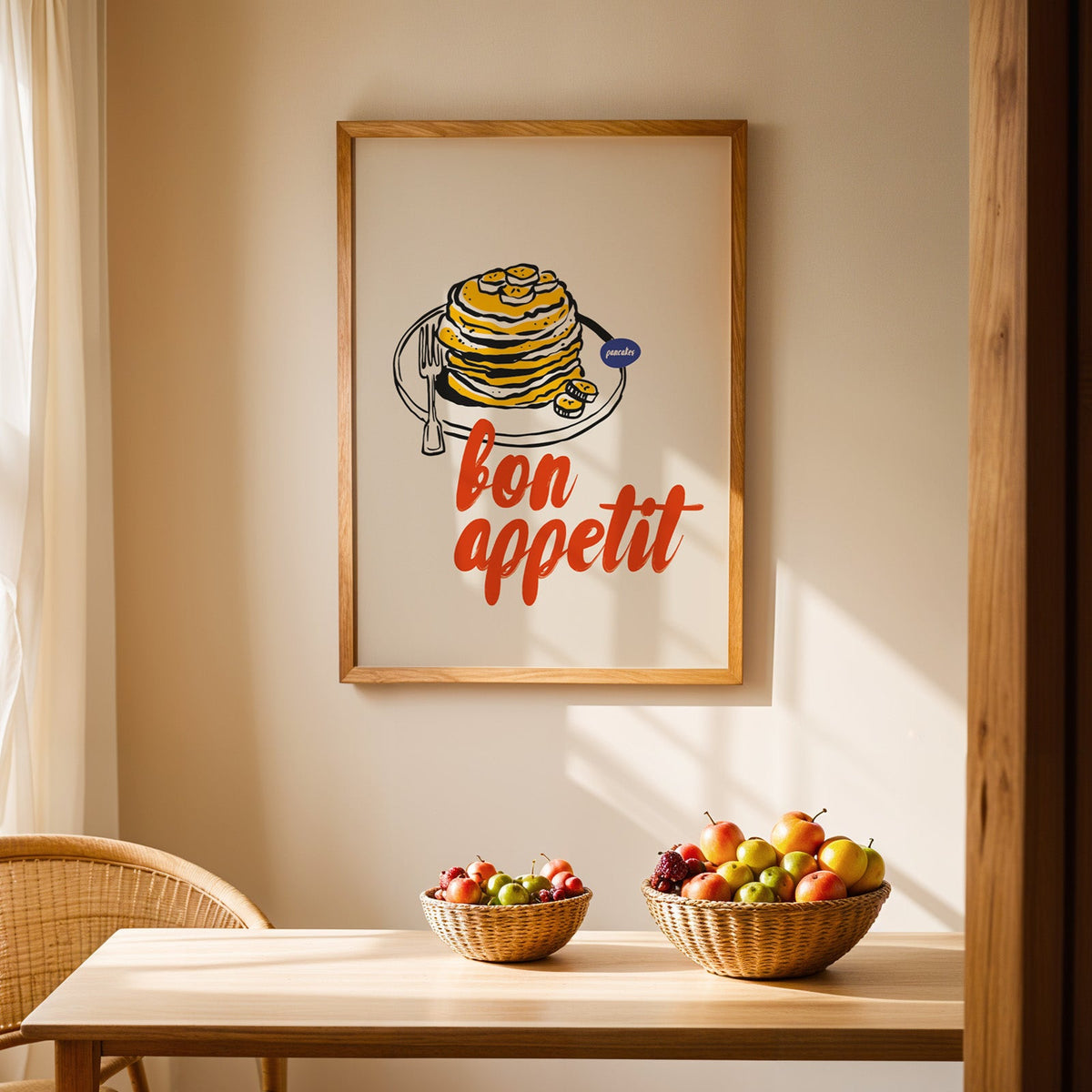 Bon Appetit pancakes print in an oak frame above a dining table with rattan chairs