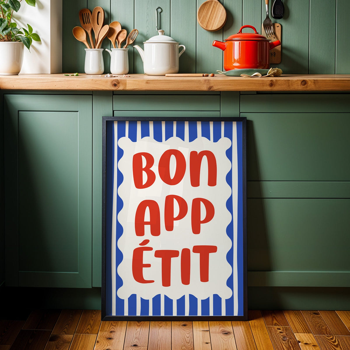 Bon appetit print in a black frame against sage green kitchen cabinets