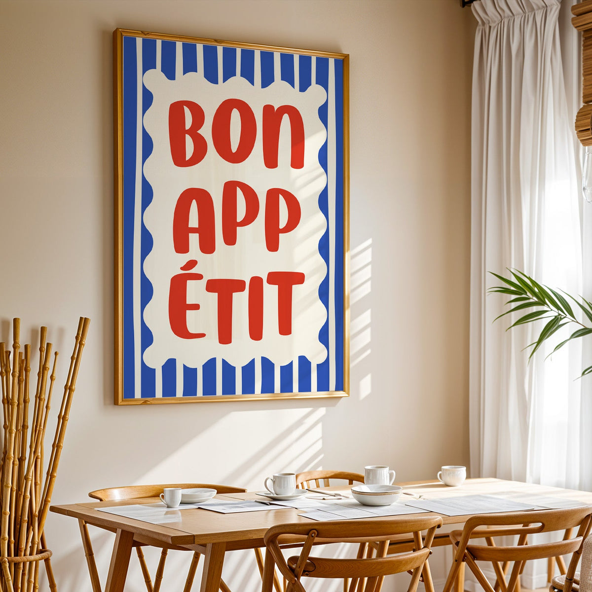 Bon appetit print in a gold frame above a sunlit breakfast table