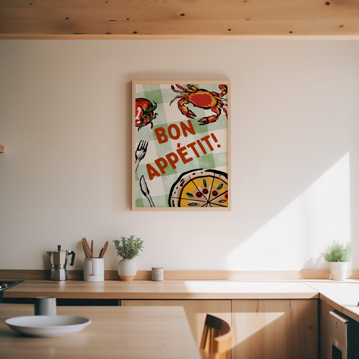 Bon Appetit crab print in an oak frame above a wood counter with a moka pot and herbs