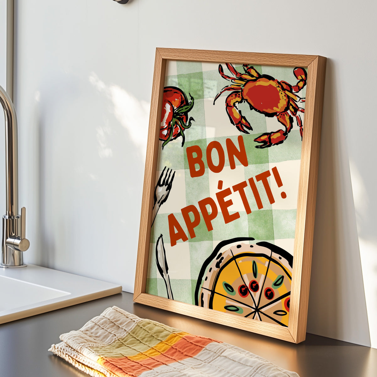 Bon Appetit crab print in an oak frame by the kitchen sink beside a striped tea towel