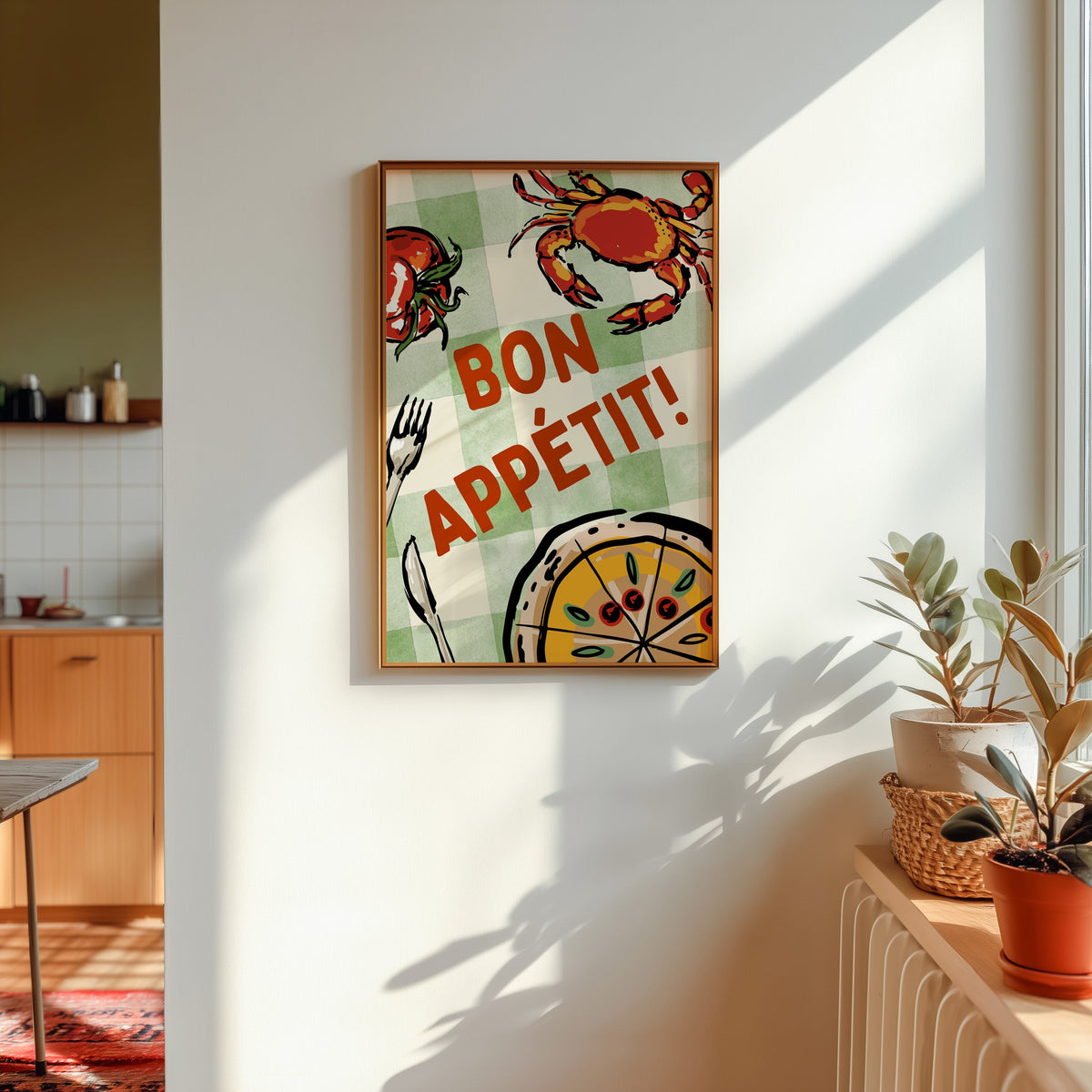 Bon Appetit crab print shown in a gold frame in sunlight with plants and a kitchen beyond