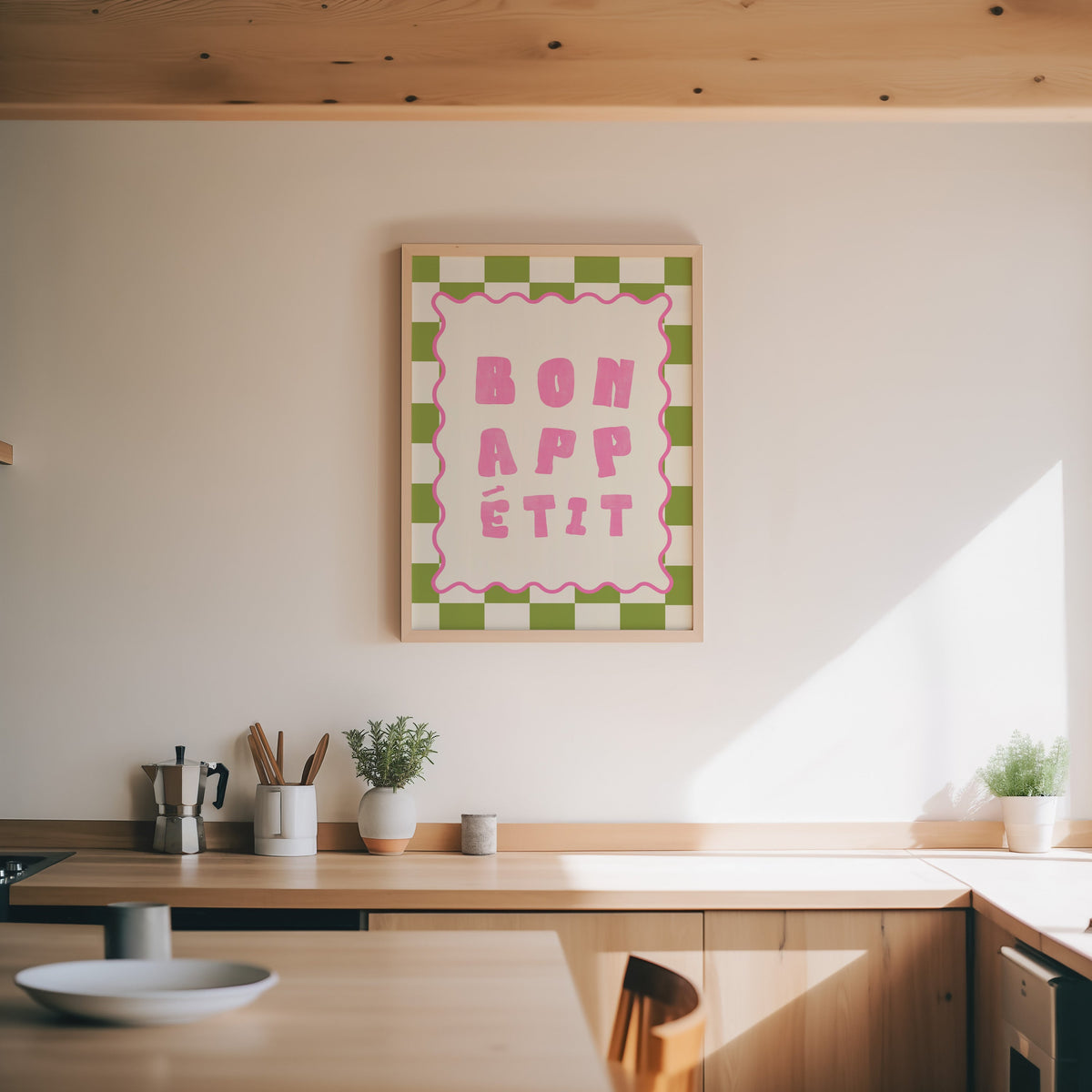 Bon Appetit check print in an oak frame above a wood counter with a moka pot and herbs