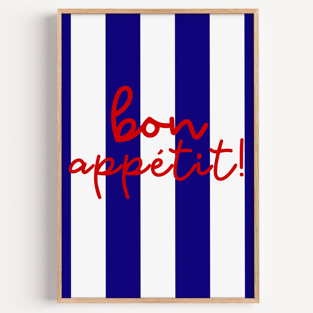 Bon appétit navy stripe print in a light oak frame on a plain white wall