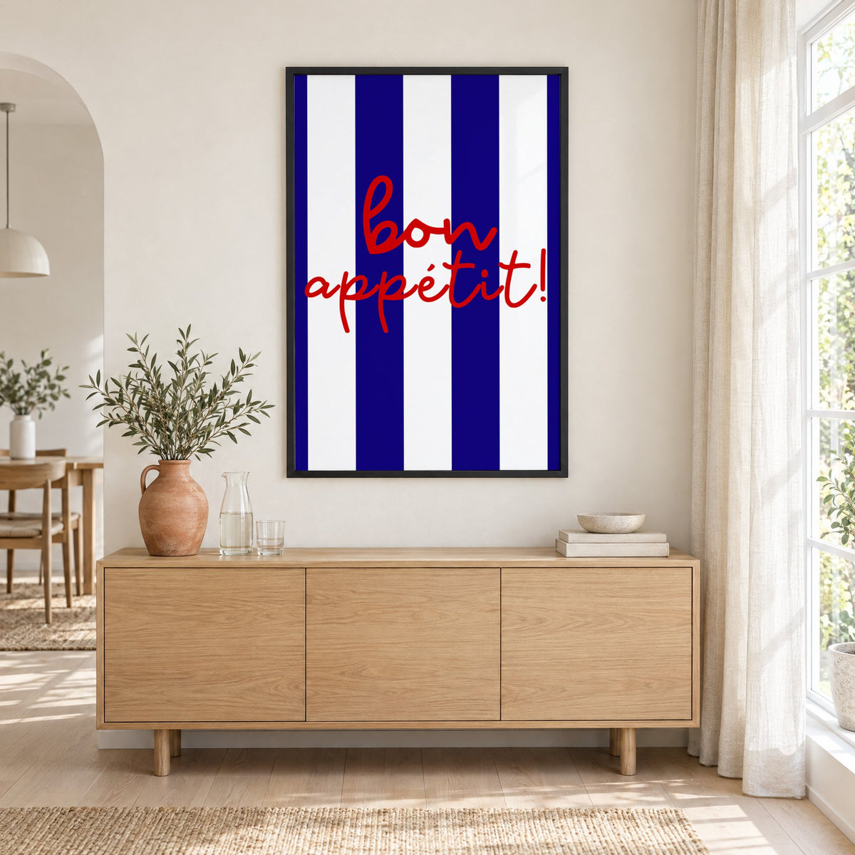 Bon appétit navy stripe print in a black frame above an oak sideboard with a terracotta vase of olive branches