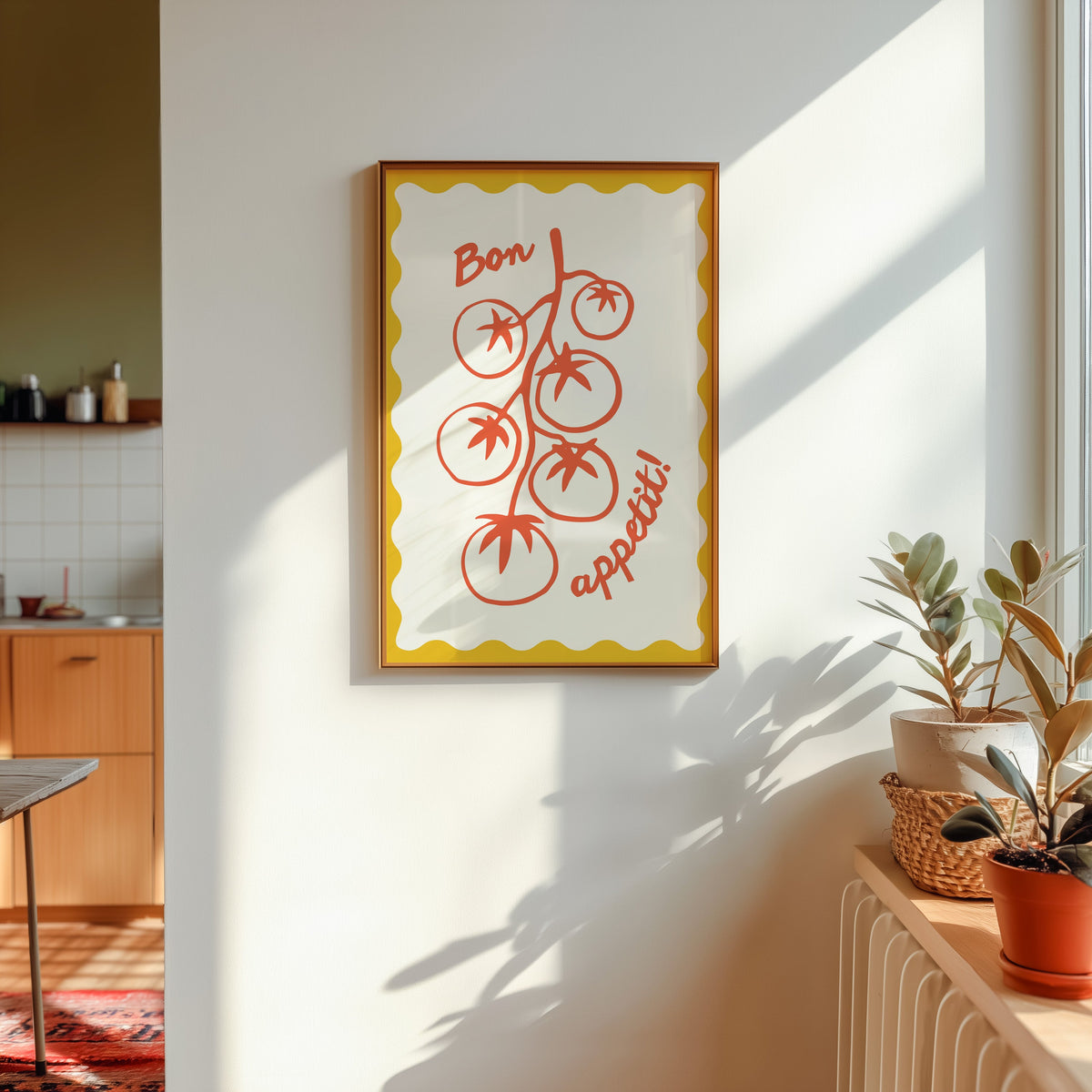 Tomato vine print shown in a gold frame in sunlight with plants and a kitchen beyond