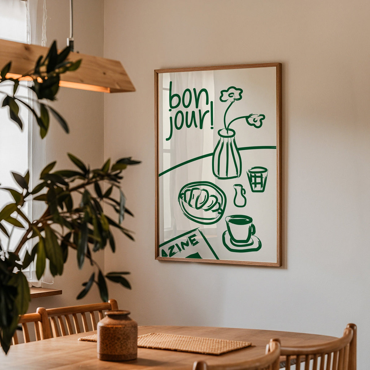 Bon jour breakfast print in a walnut frame above a dining table beside an olive tree