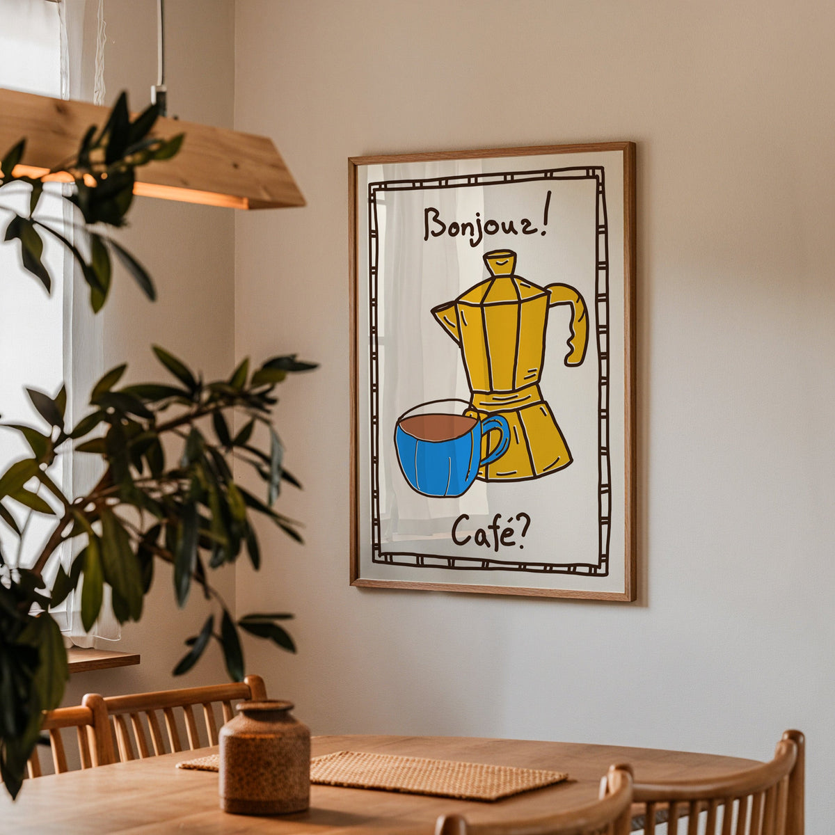 Bonjour cafe moka pot print in a walnut frame above a dining table by an olive tree