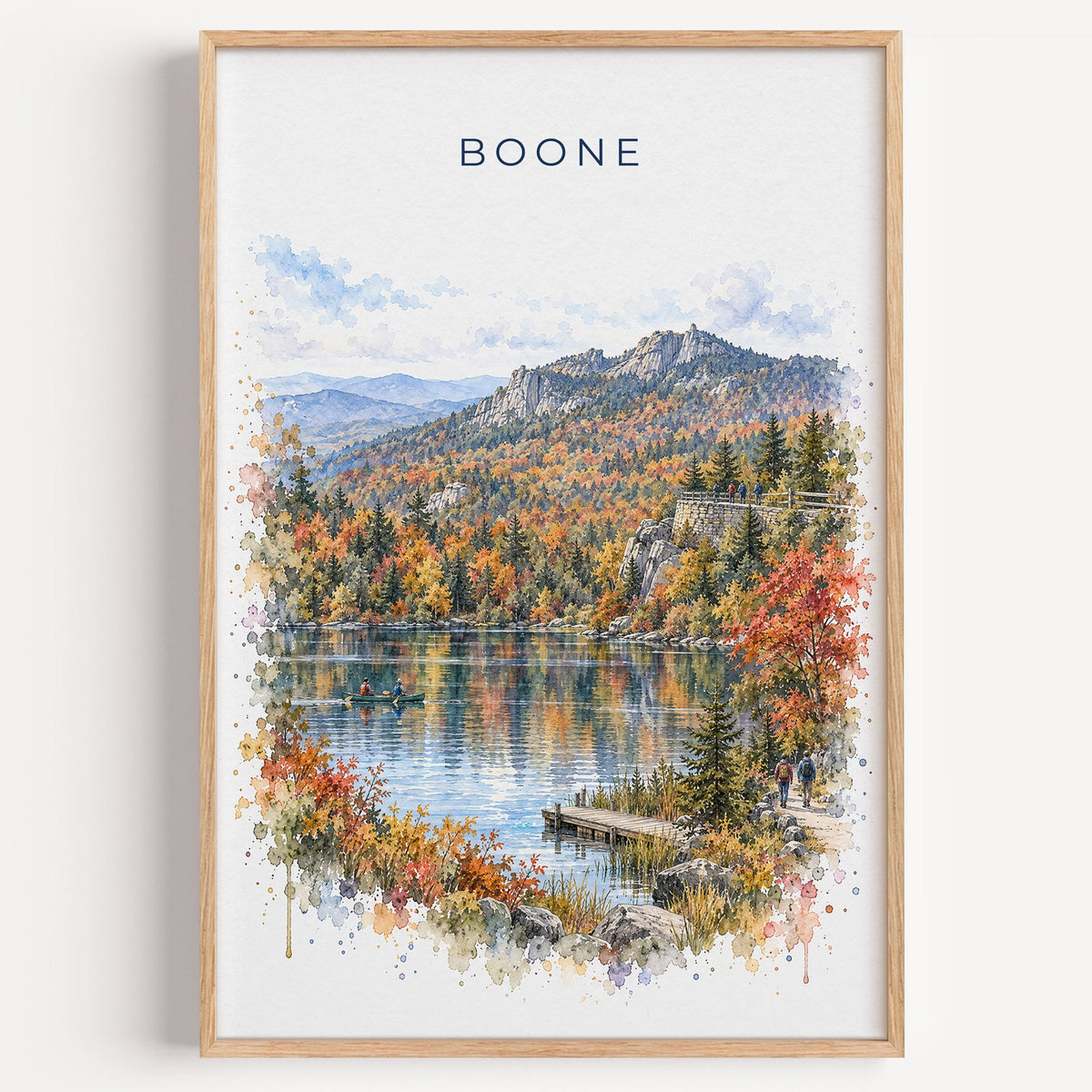 Boone, North Carolina watercolor print in a light oak frame on a plain white wall