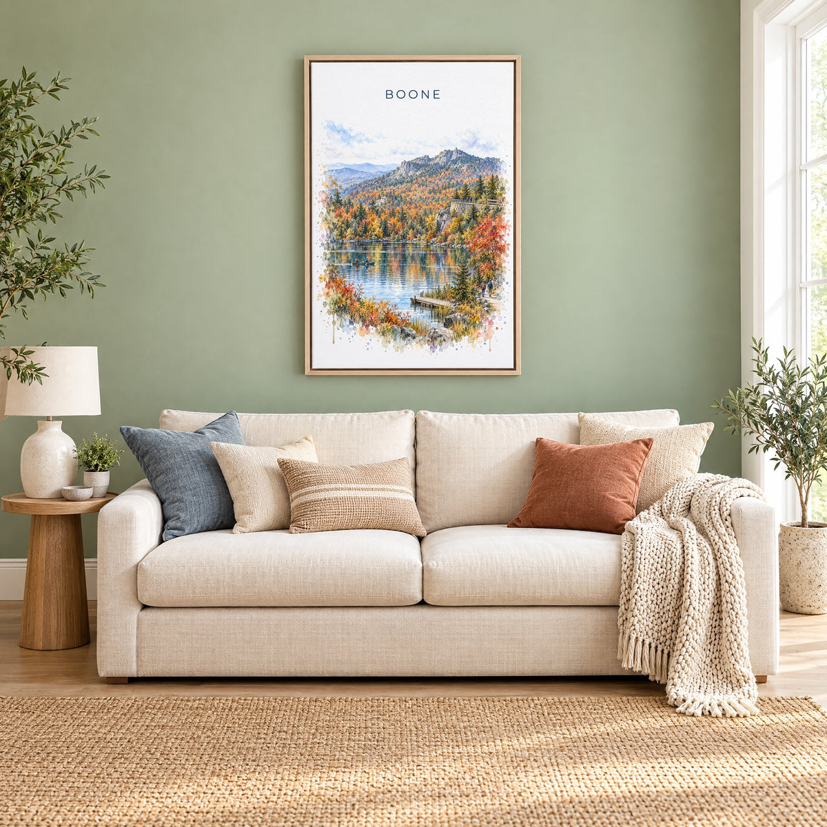 Boone, North Carolina watercolor print as a natural floater canvas above a cream linen sofa on a sage green wall