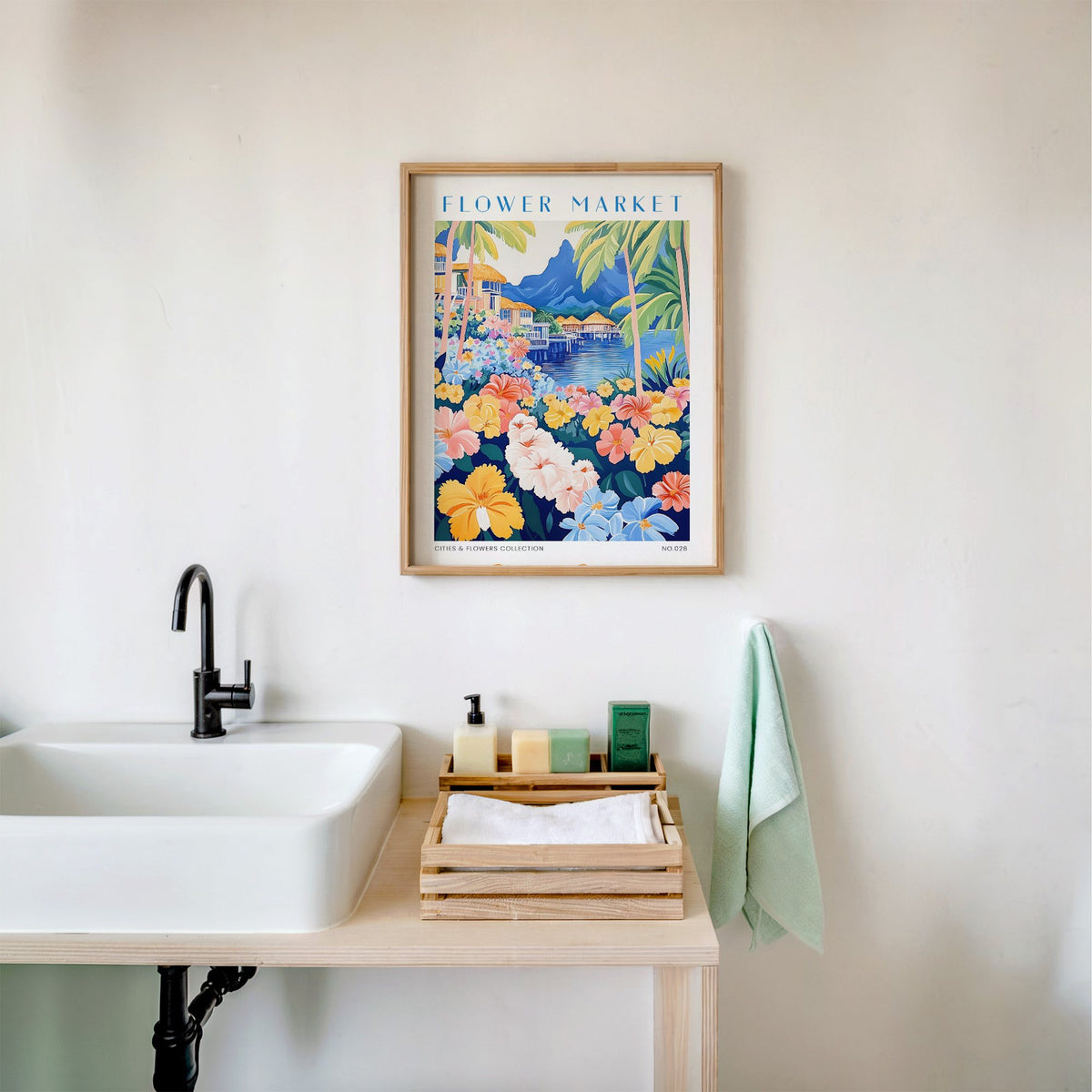 Bora Bora flower market print in an oak frame above a white bathroom sink with folded towels