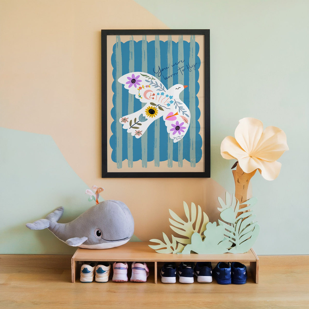 White dove covered in flowers nursery print in a black frame on a mint and peach wall above a whale plush