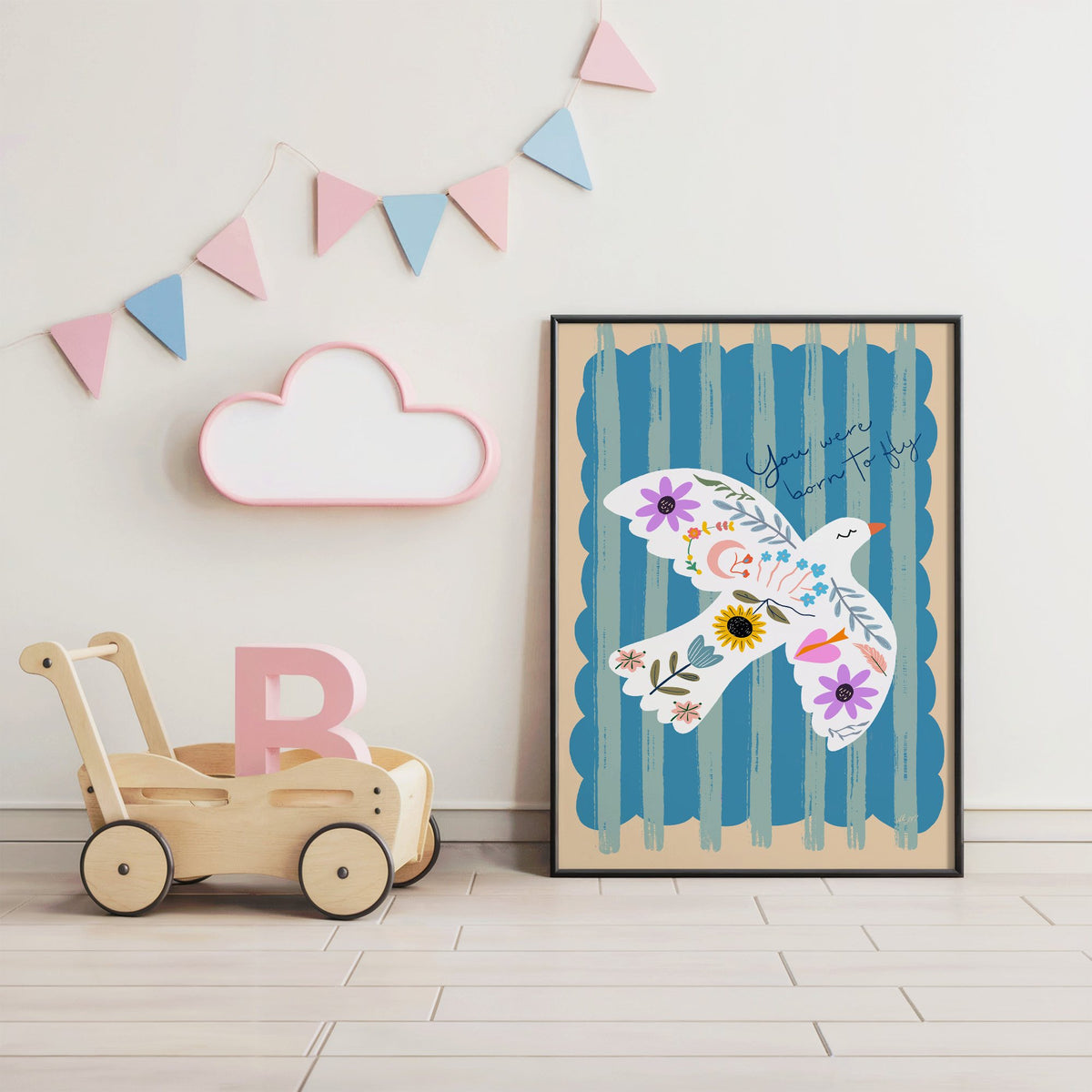 White dove covered in flowers nursery print in a black frame under pastel bunting by a wooden baby walker