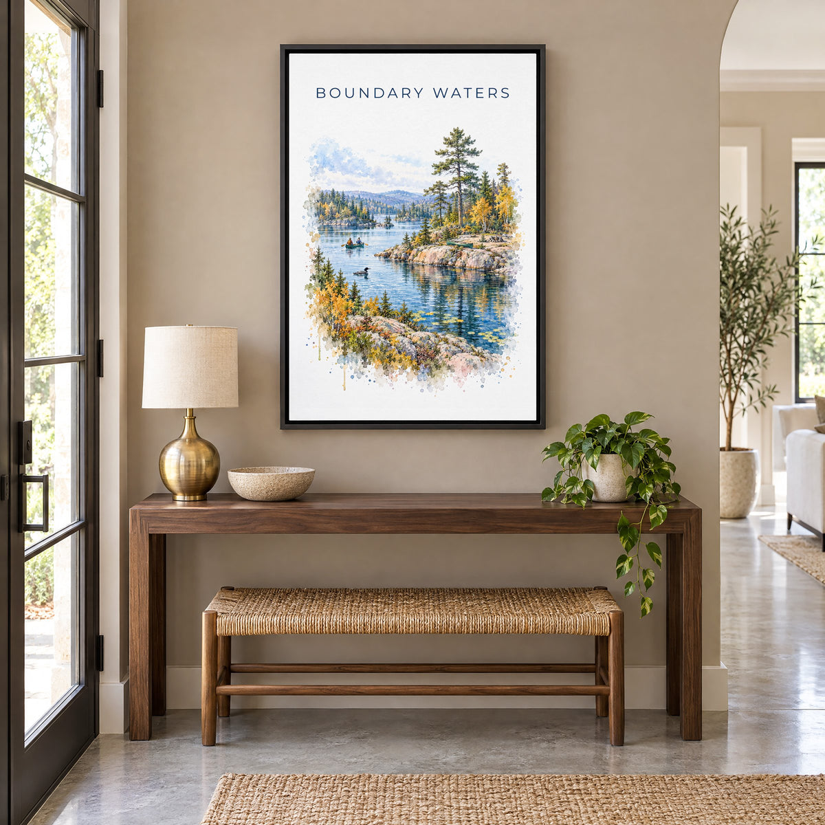 Boundary Waters watercolor print as a black floater canvas above a walnut console and woven bench in an entryway