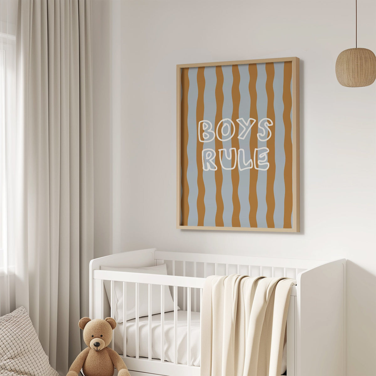 Boys rule wavy stripe nursery print in an oak frame above a white crib with a teddy bear