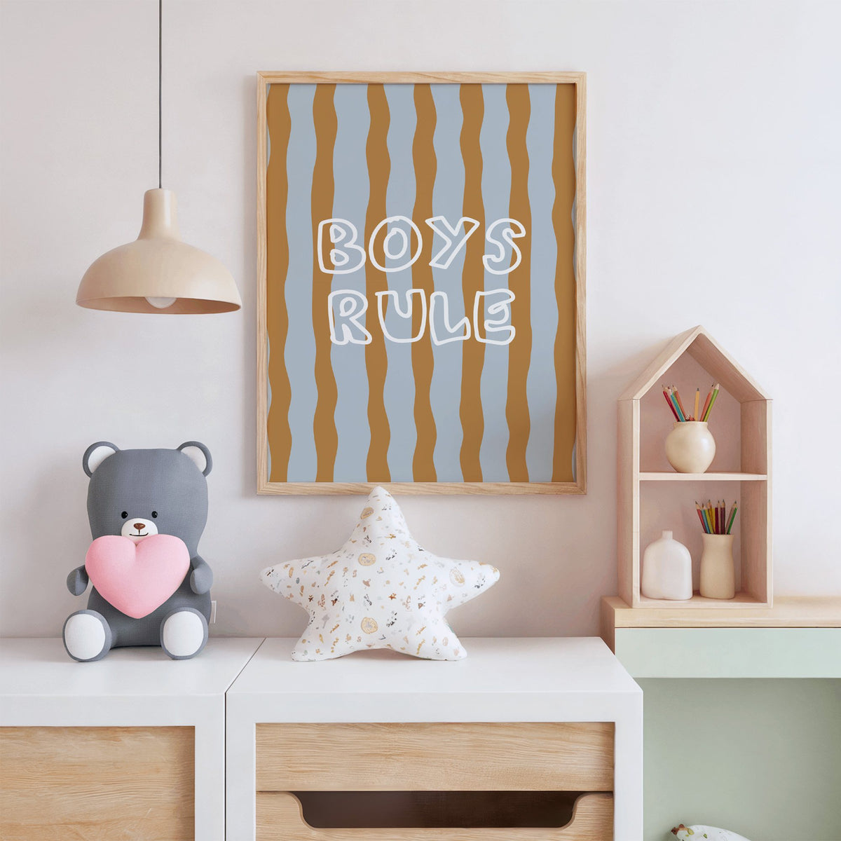 Boys rule wavy stripe nursery print in an oak frame above a white dresser with a star pillow and house shelf