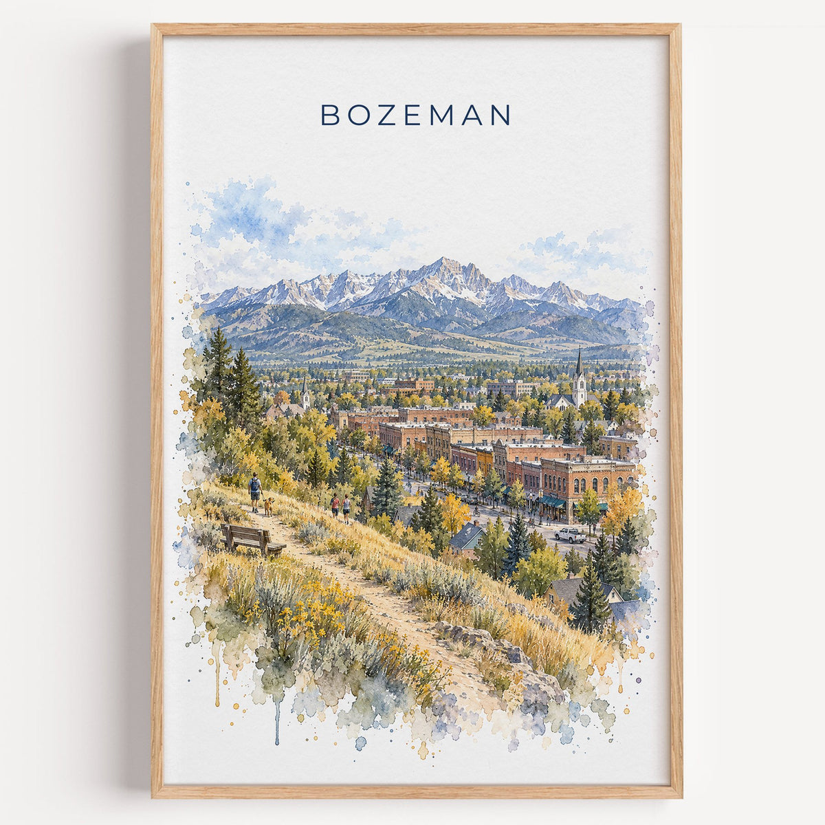 Bozeman watercolor print in a light oak frame on a plain white wall
