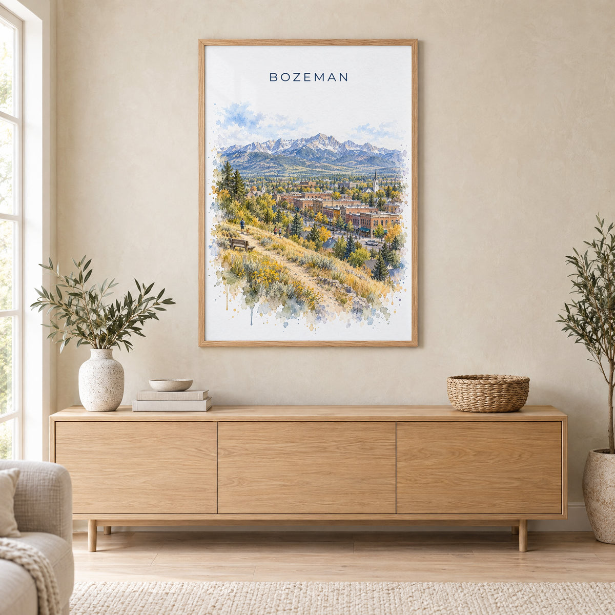 Bozeman watercolor print in an oak frame above a light wood sideboard in a Scandinavian living room