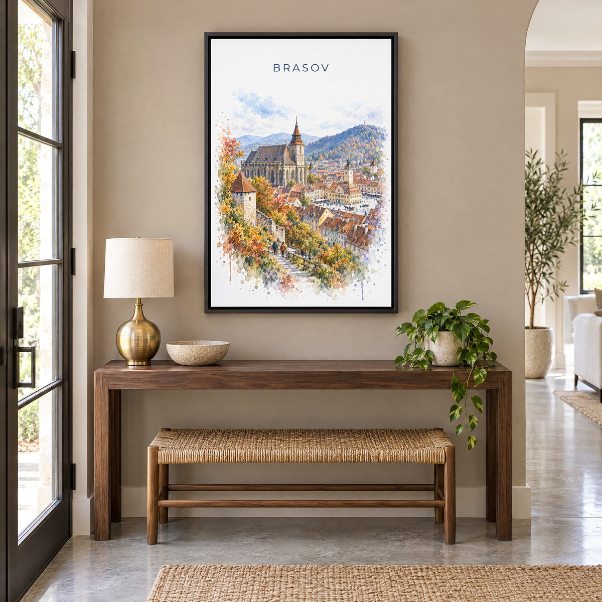 Brasov watercolor print as a black floater canvas above a walnut console and woven bench in an entryway