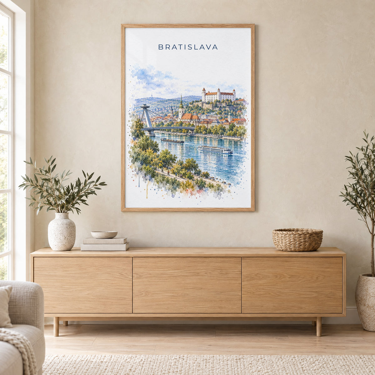 Bratislava watercolor print in an oak frame above a light wood sideboard in a Scandinavian living room