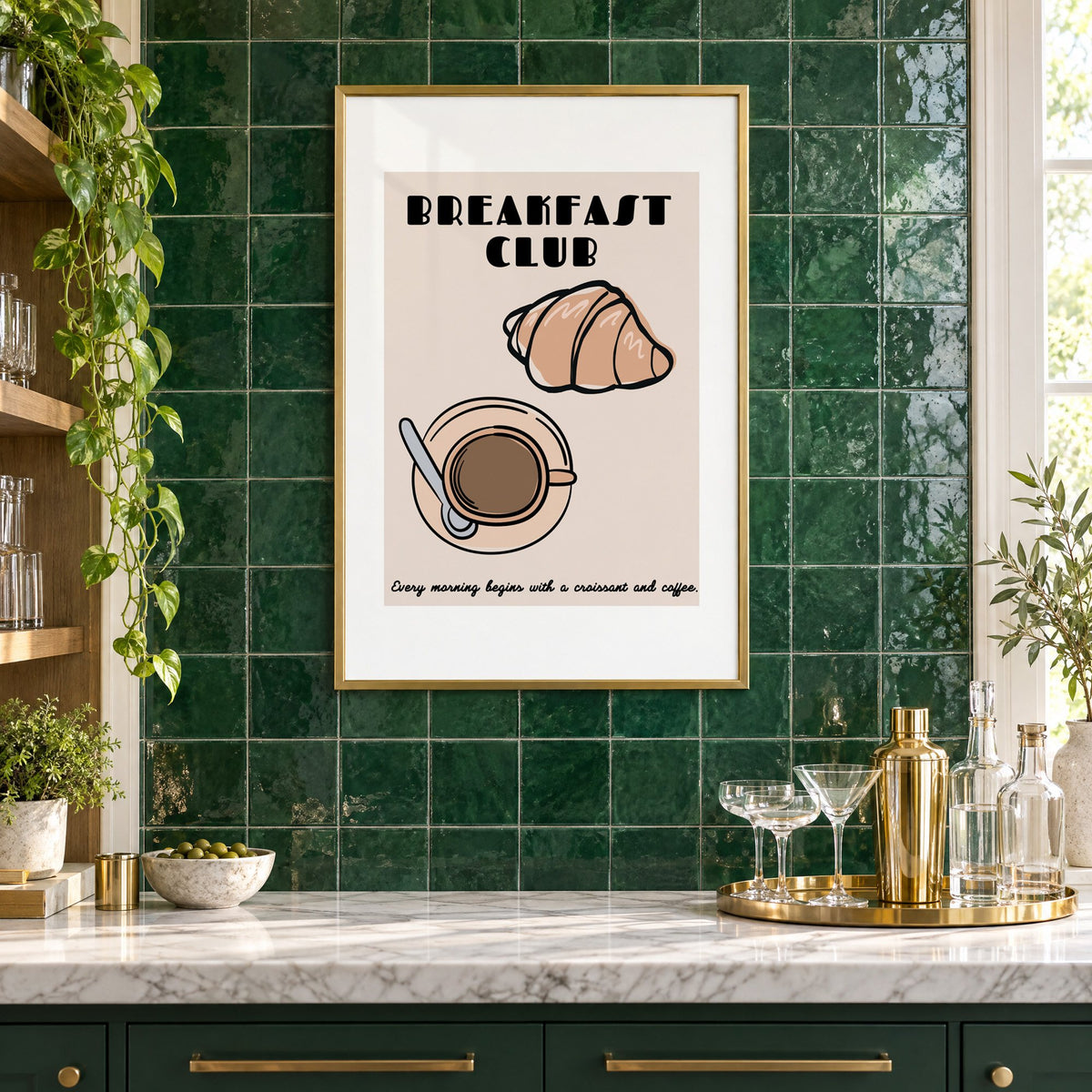 Breakfast Club croissant and coffee print in a brass frame on emerald green tiles above a home bar with coupe glasses