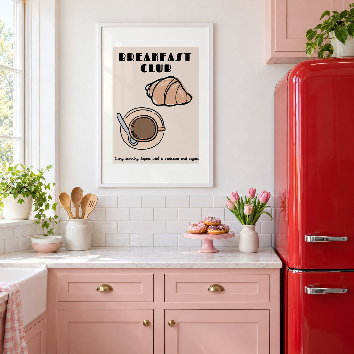 Breakfast Club croissant and coffee print in a white frame in a pink kitchen beside a red retro fridge