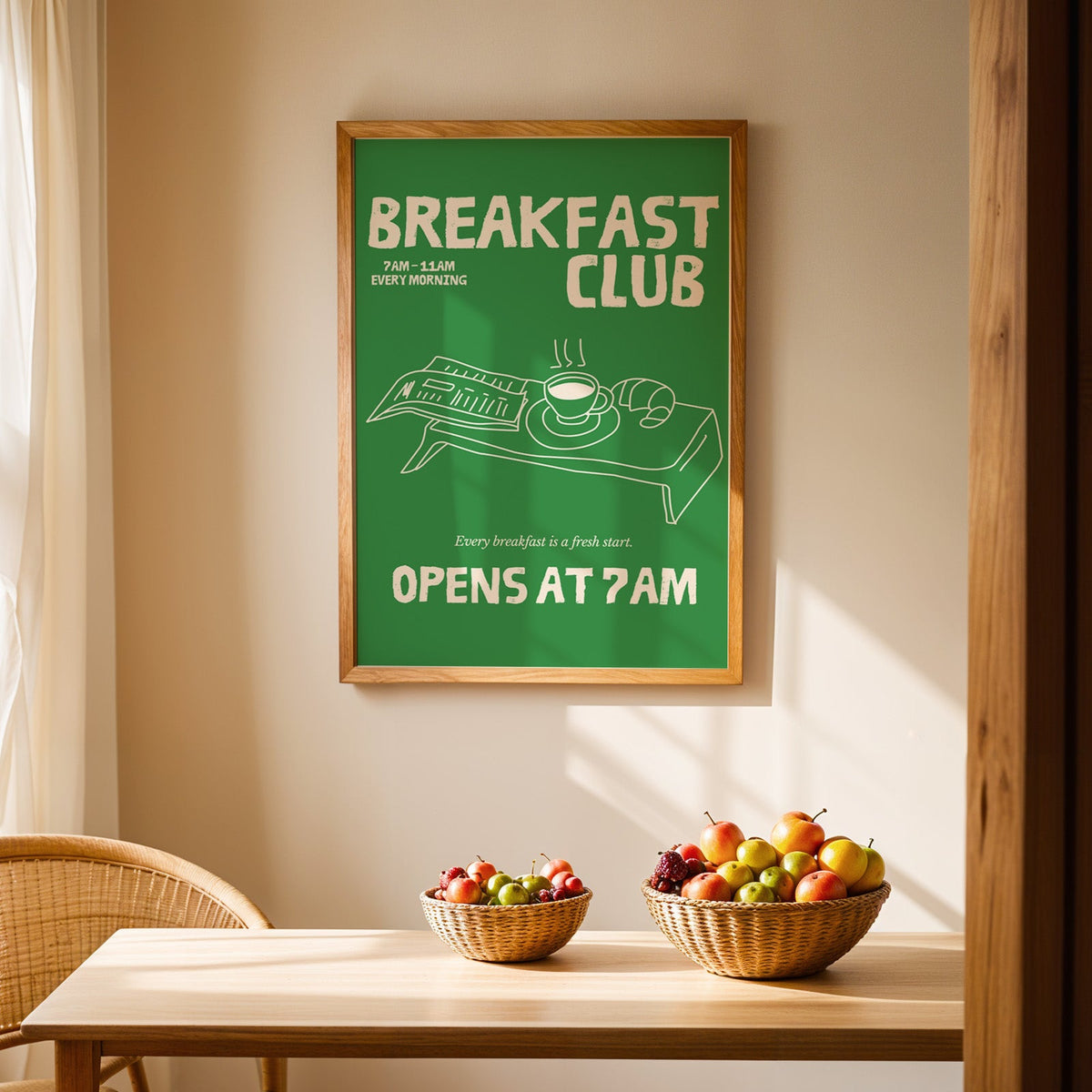 Breakfast Club green tray print in an oak frame above a light wood dining table with baskets of fruit