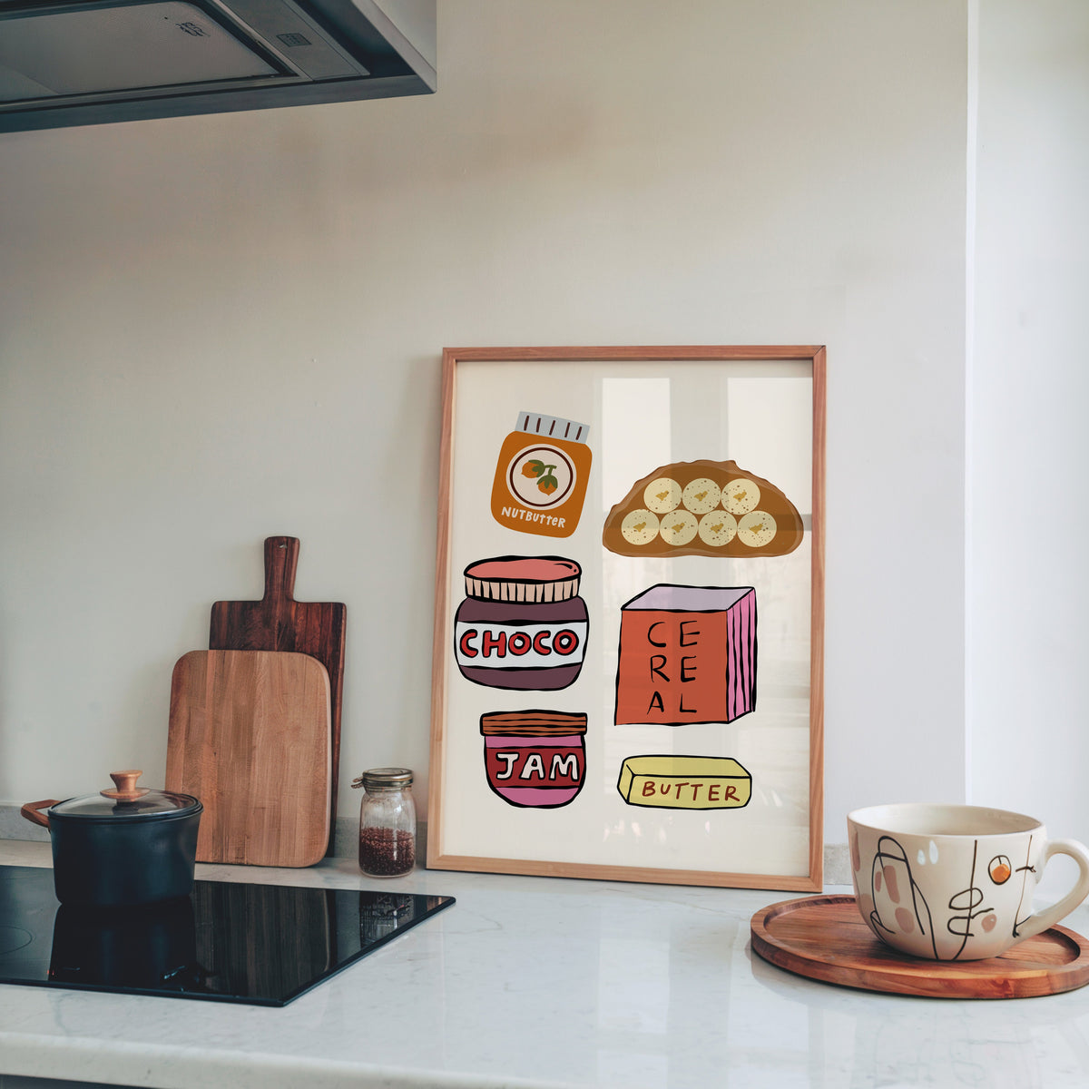 Breakfast pantry jars print in a pine frame leaning on a marble kitchen counter beside chopping boards